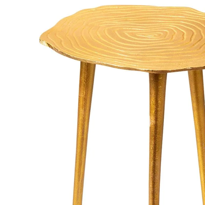Close-up of gold accent table top with textured concentric pattern and slender legs