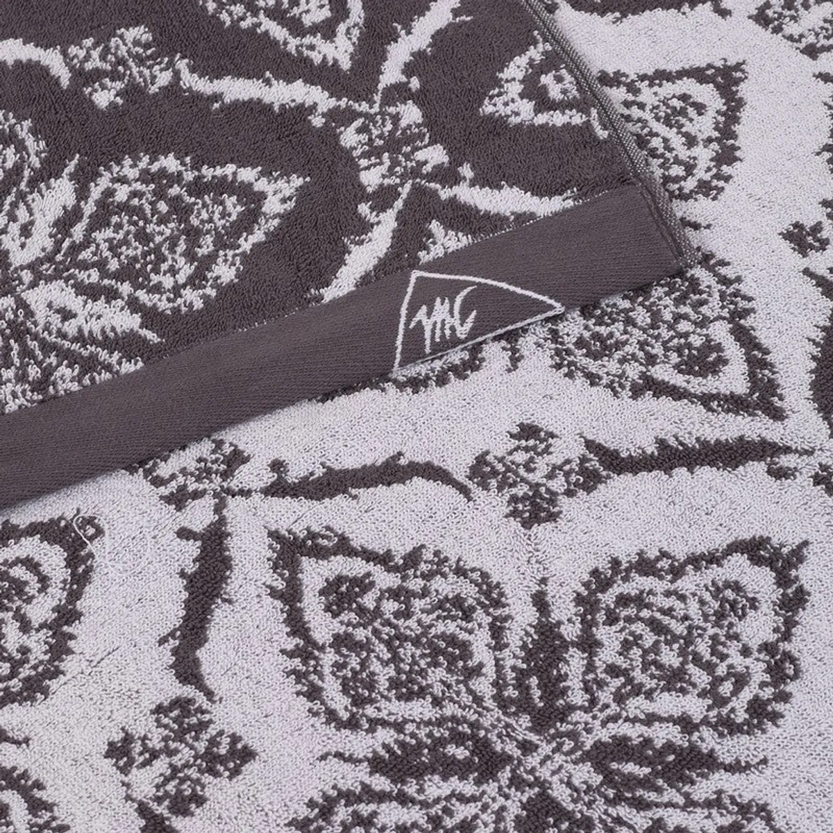 Close-up of the towel's grey floral pattern and textured cotton surface