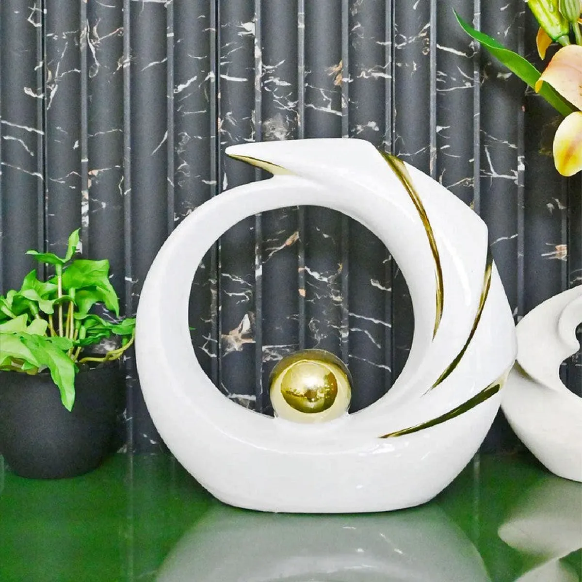White circular showpiece with gold sphere and gold accents on a dark backdrop