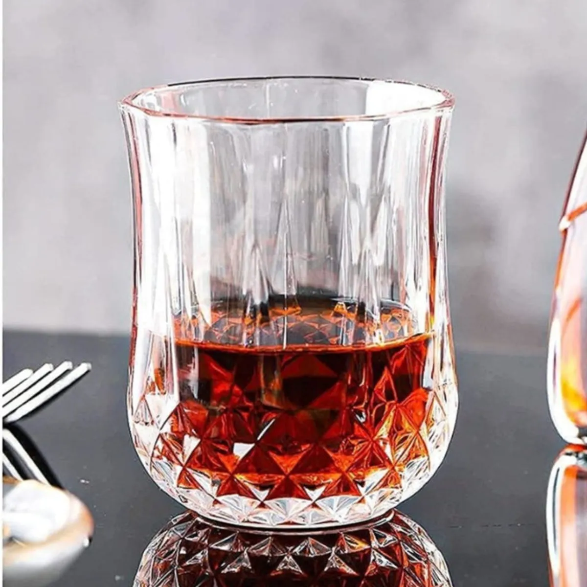 Close-up of a clear whisky glass with faceted geometric detailing