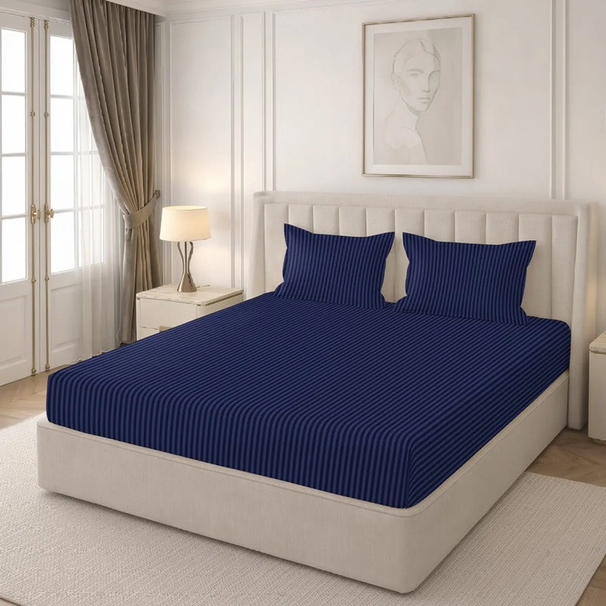 Angled view of navy striped bedsheet with two matching pillow covers on an upholstered bed