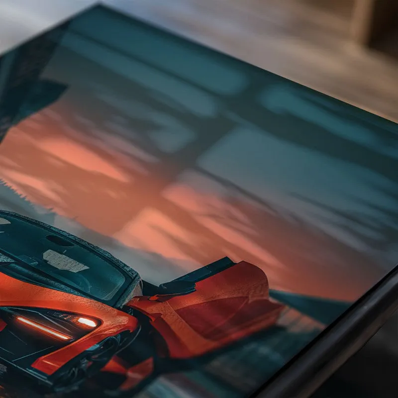 Close-up of glossy poster with orange sports car and teal sky