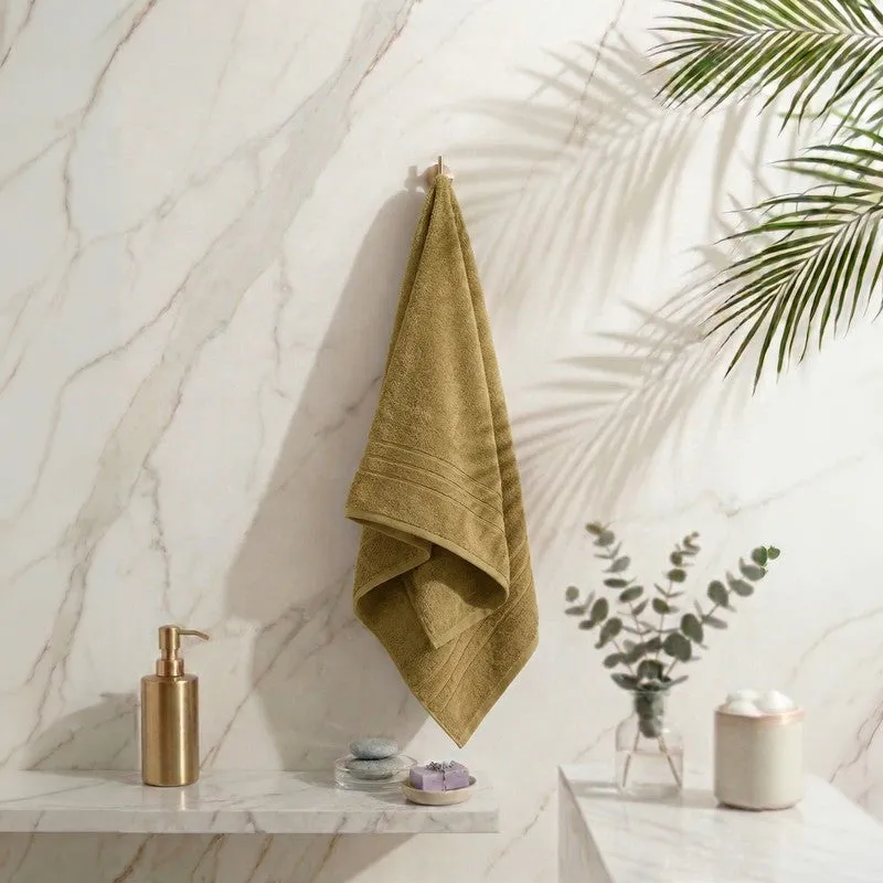 Olive green bath towel hanging in a bathroom setting
