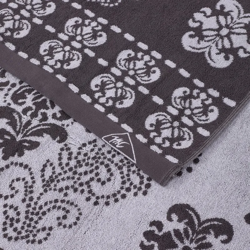 Close-up of grey floral bath towel with woven border detail