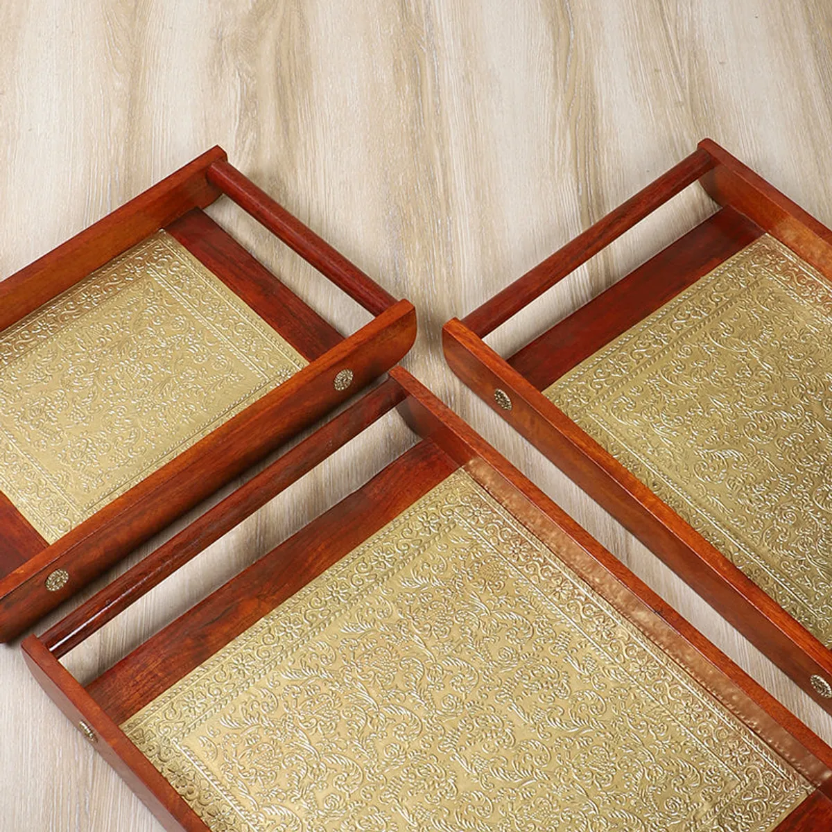 Three brown rectangular trays nested together with gold patterned centres visible