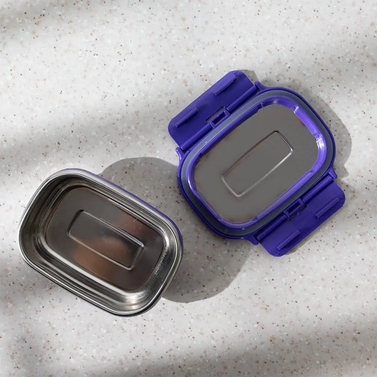 Open purple lunch box showing its stainless steel interior and lid
