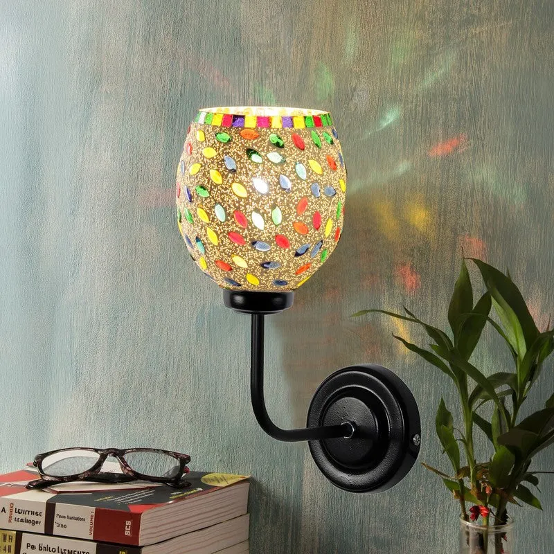 Lit multicolour mosaic wall lamp casting colourful reflections on the wall