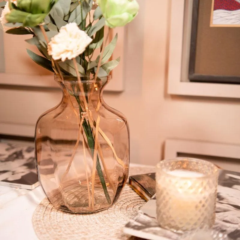 Close-up of peach glass vase with dried stems and flowers