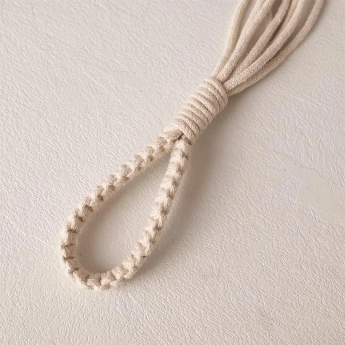 Close-up of a white macrame loop and braided cord