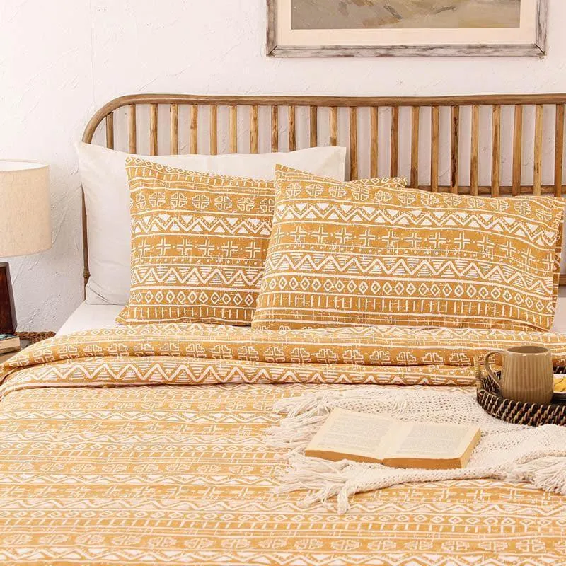 Yellow patterned dohar styled across a bed with matching cushions