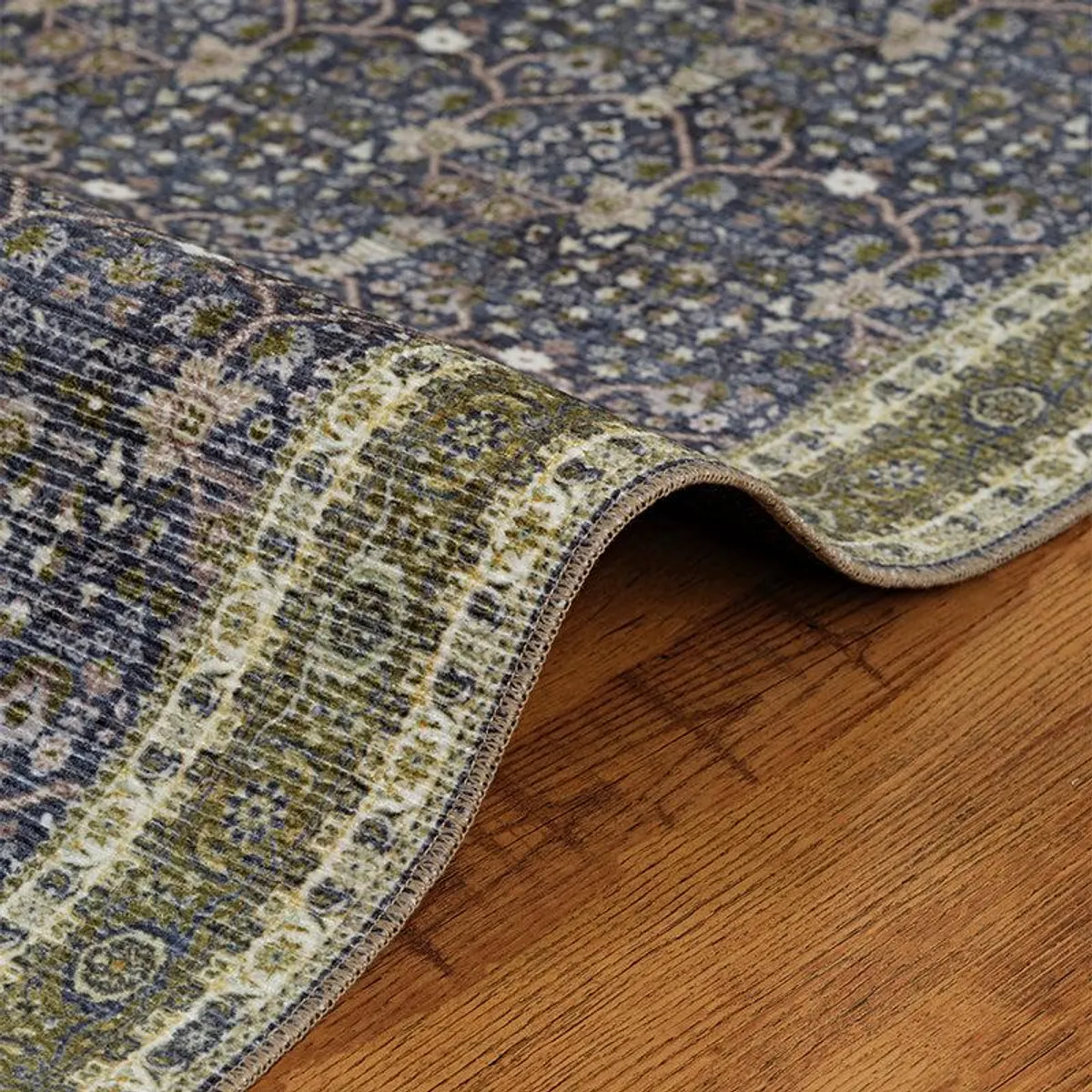 Rolled corner of patterned flat carpet showing its textured surface and edging