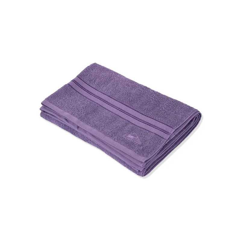 Folded purple bath towel on a plain white background