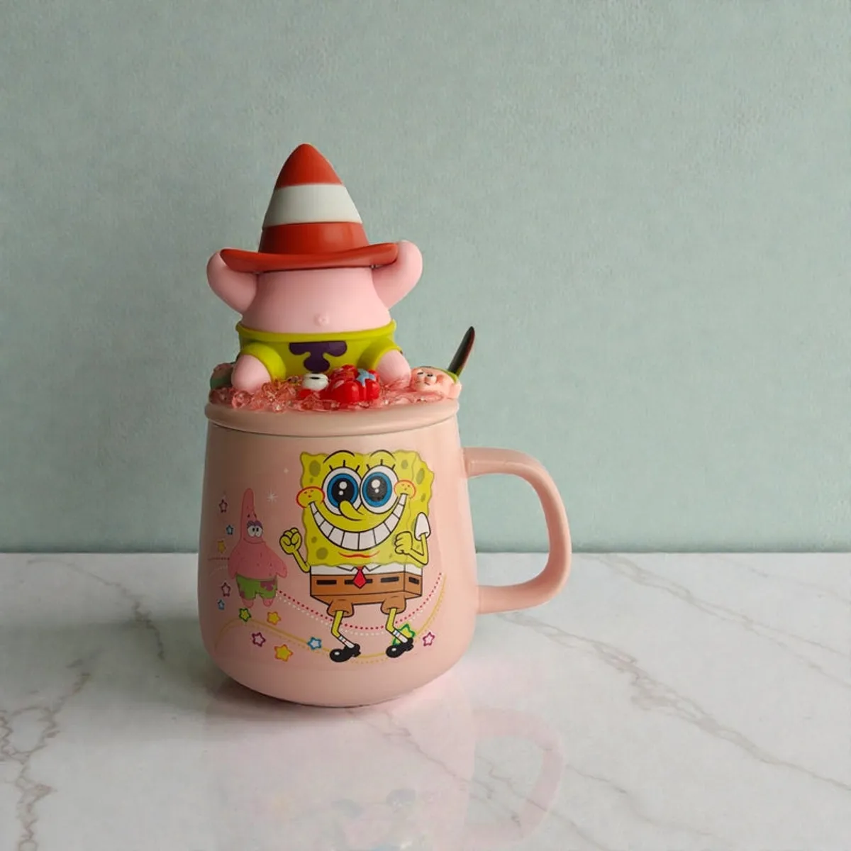 Pink cartoon character mug topped with a 3D figurine lid