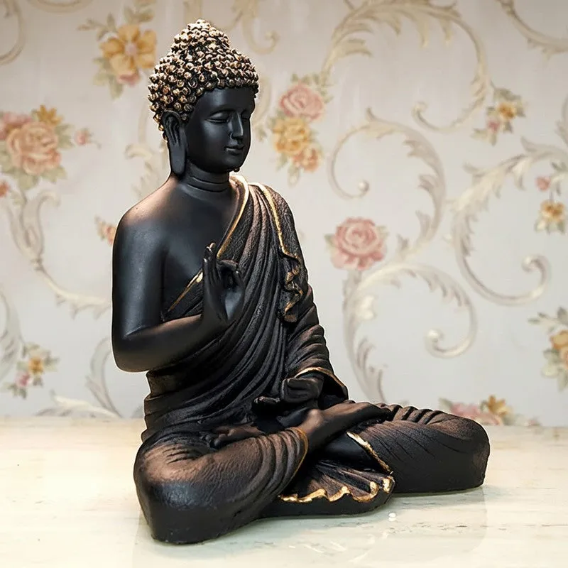 Side angle of seated black Buddha idol with gold accents