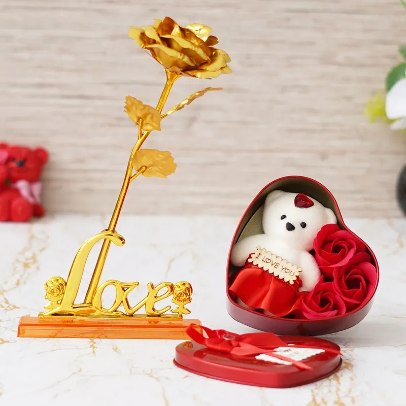 Gold rose ornament beside an open red heart-shaped gift box
