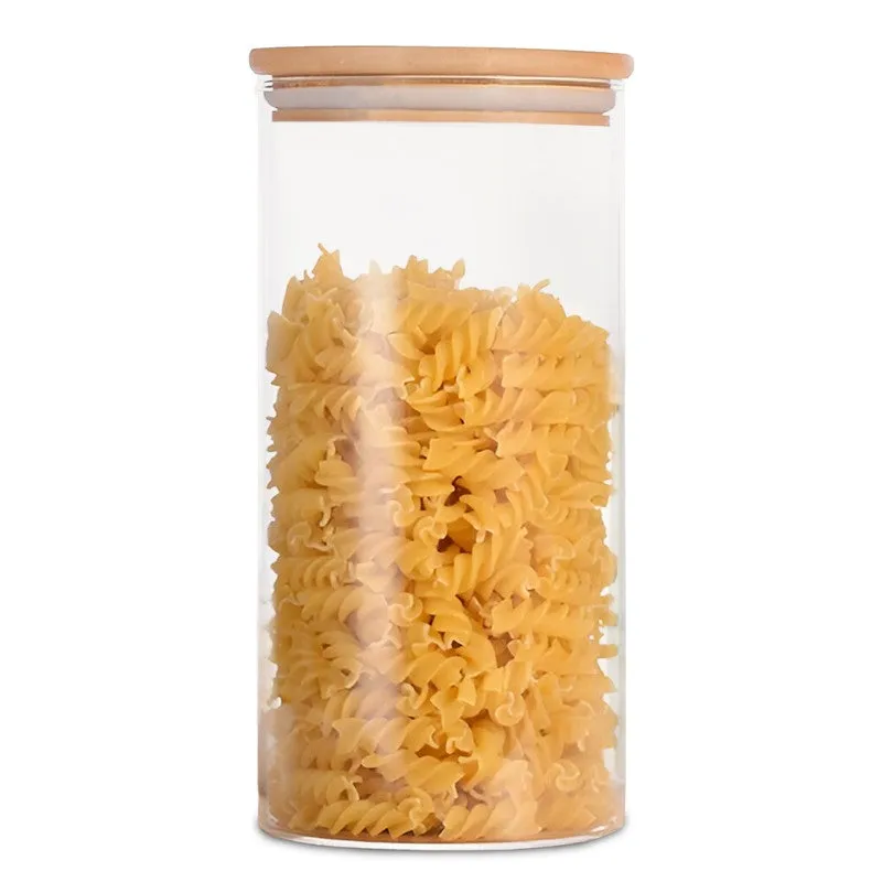Front view of a transparent cylindrical glass jar with bamboo lid, filled with spiral pasta.
