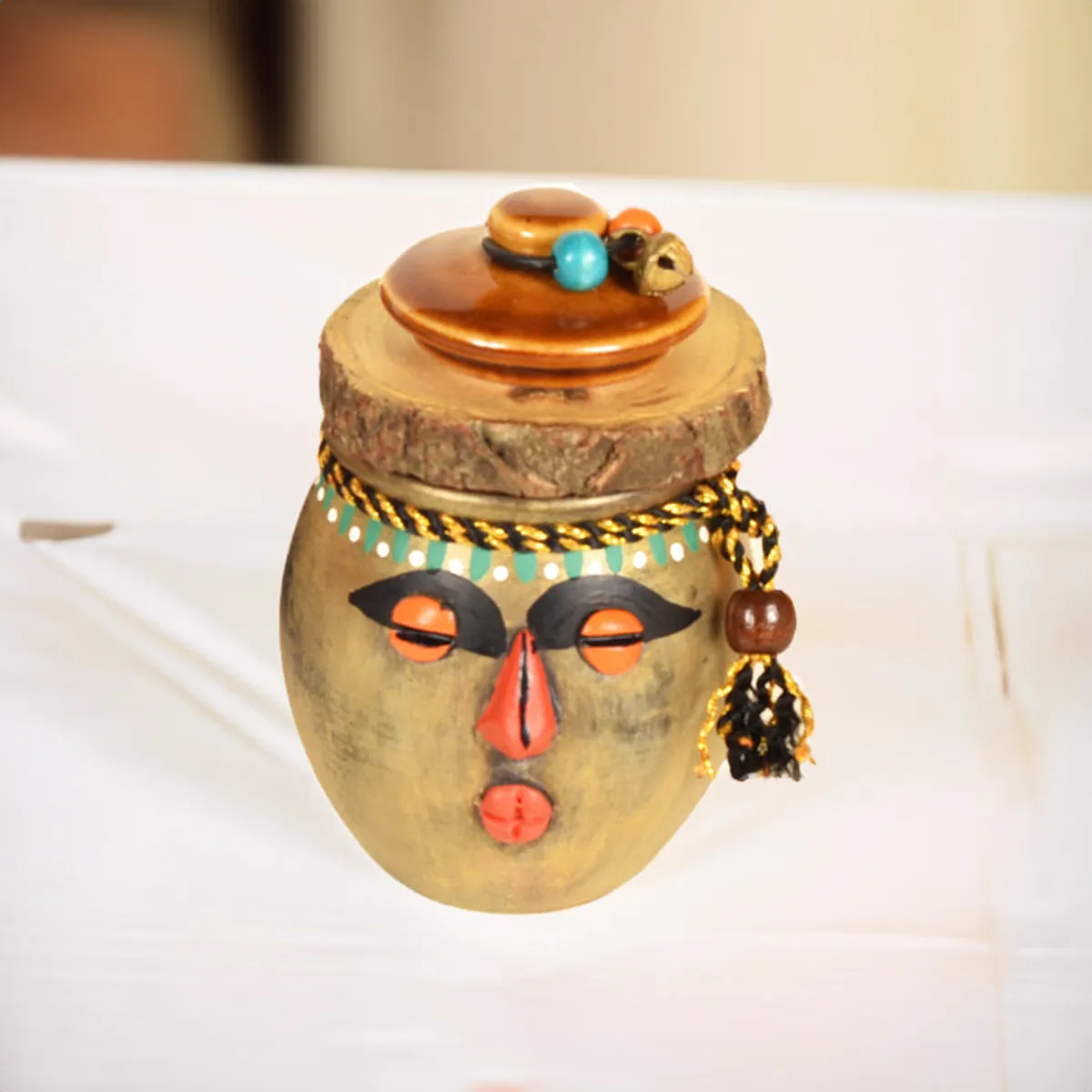 Close-up of a decorative jar with an expressive face and embellished lid
