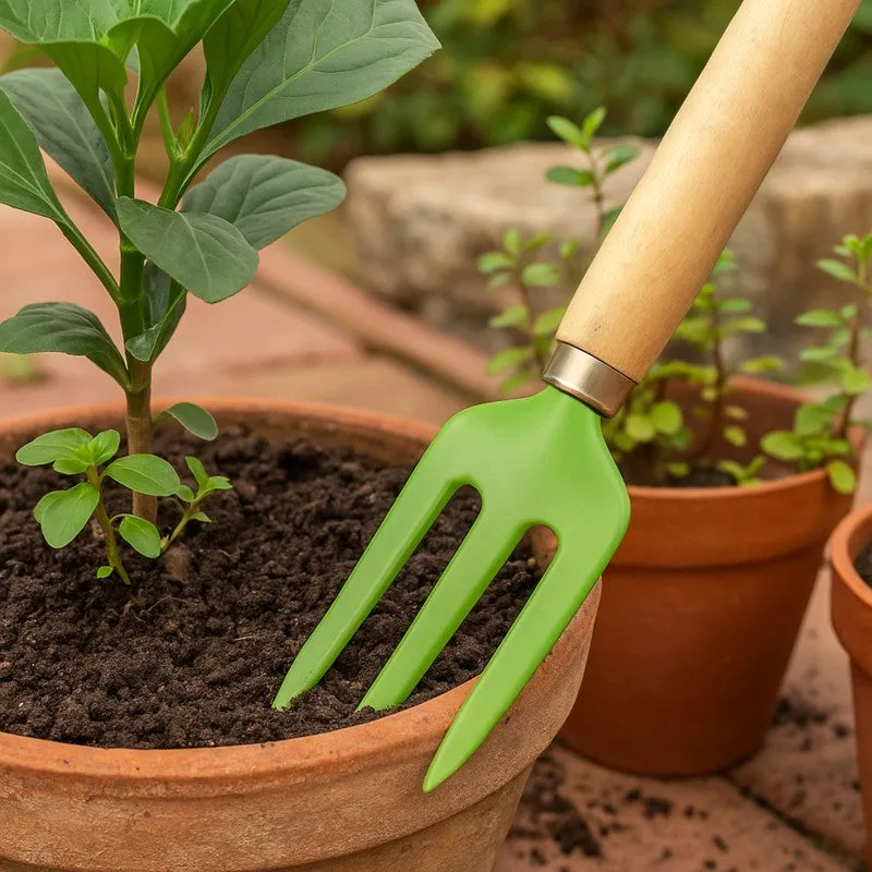 Close-up of the green garden fork working in a terracotta planter