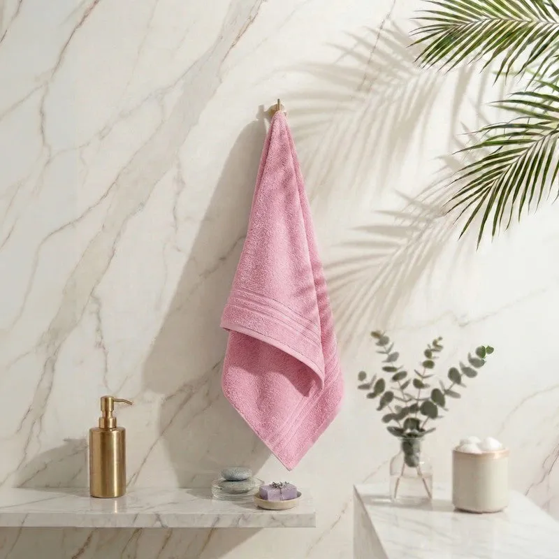 Light pink bath towel hanging in a bathroom setting