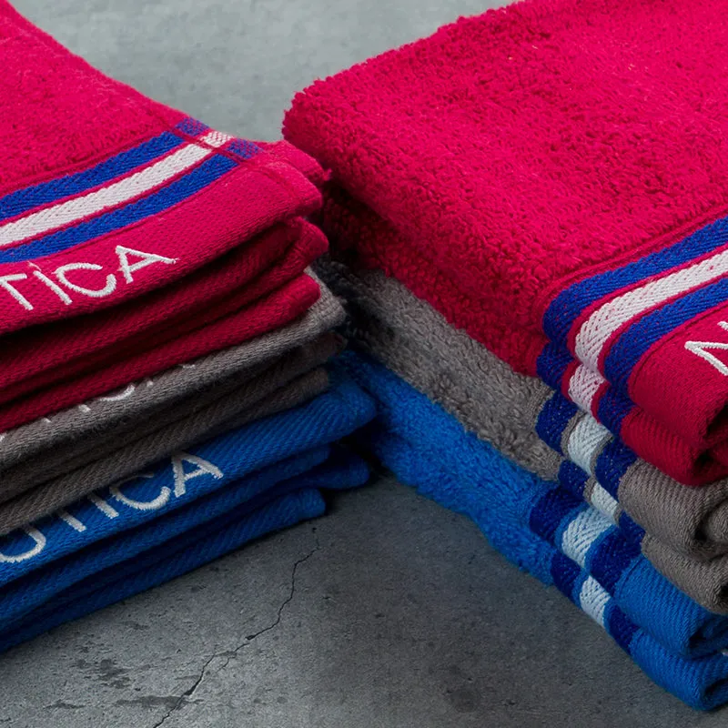 Close-up stacks of burgundy, grey and blue plush striped face towels