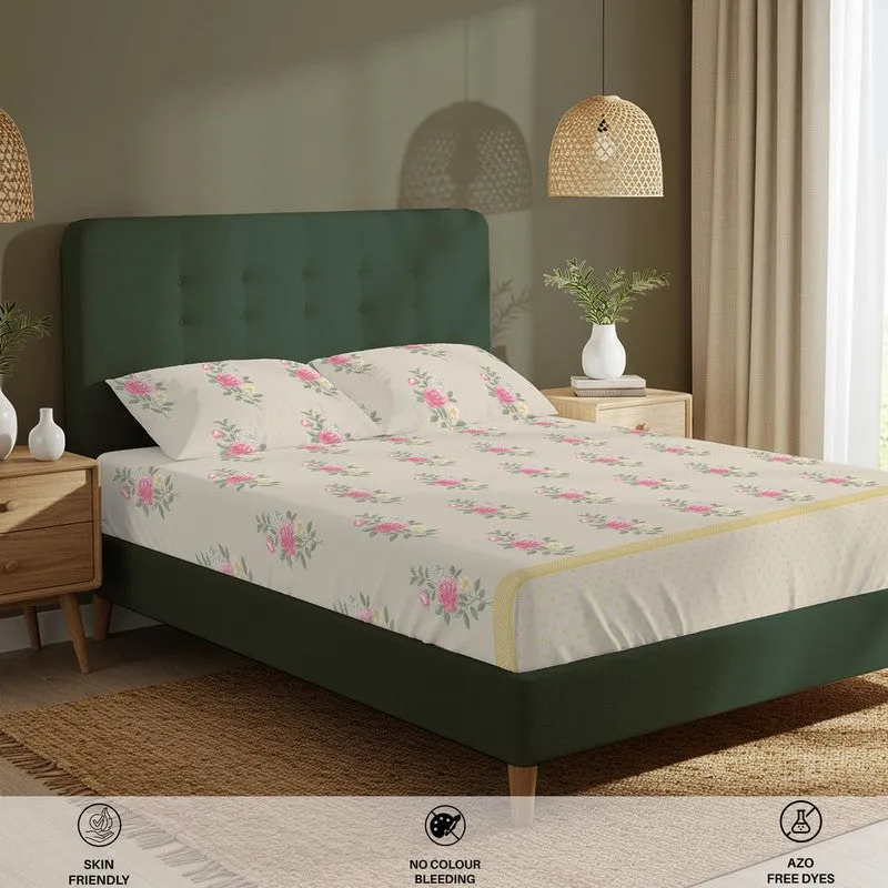 Angled view of floral bedsheet with matching pillow covers on a green bed