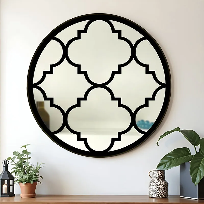 Round wall mirror with black geometric motif on a light wall