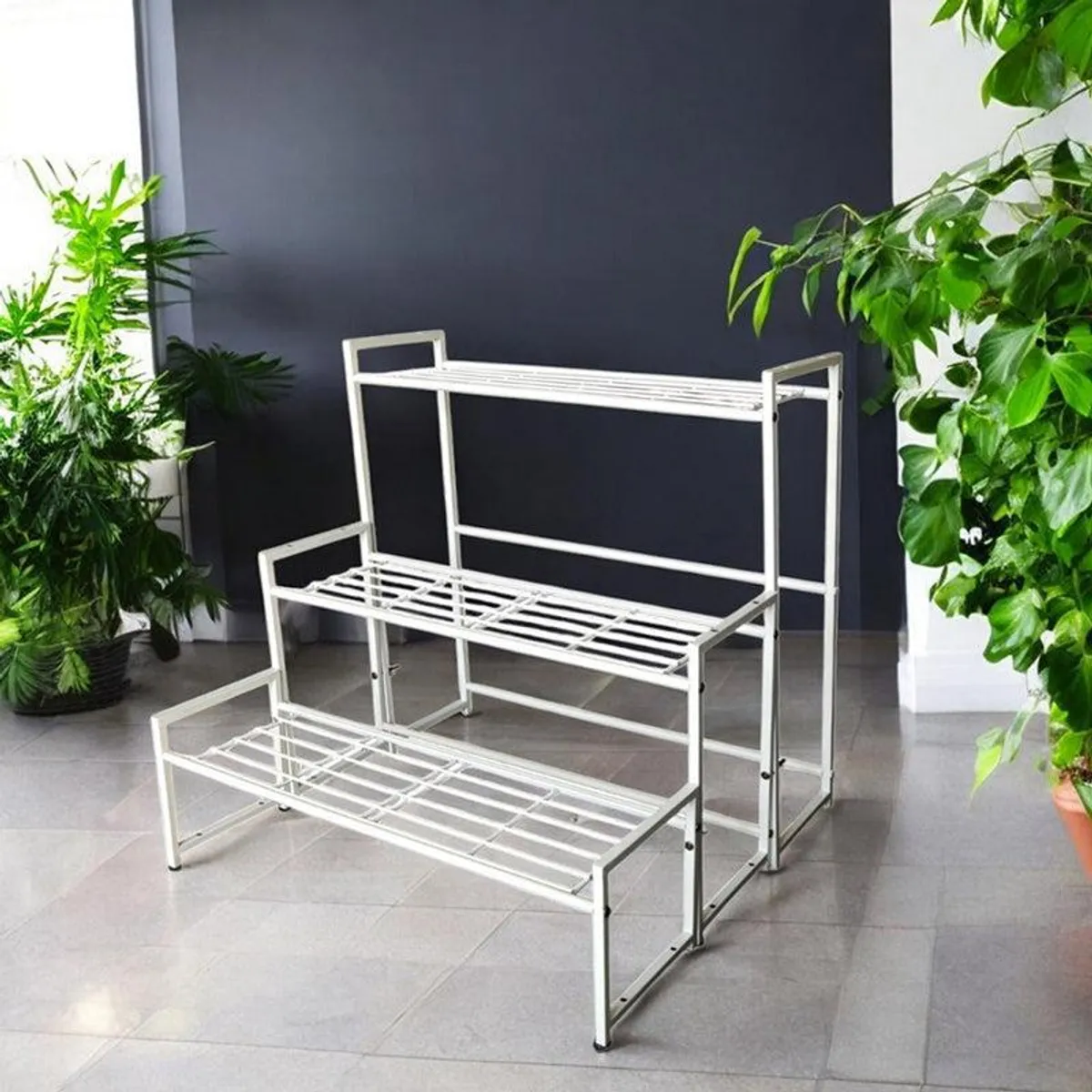 Angled view of an empty white three-tier metal planter stand