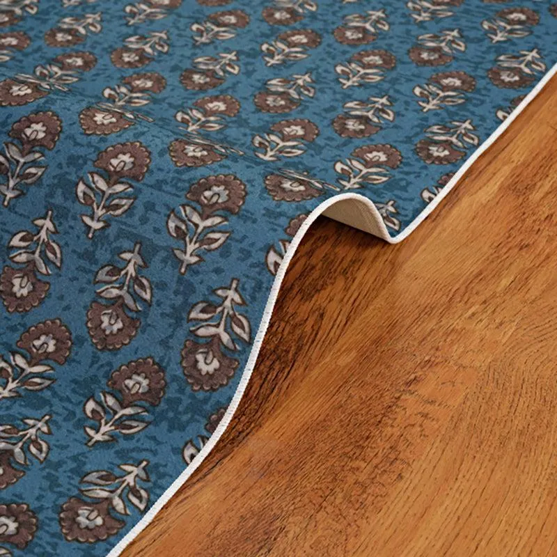 Blue patterned carpet edge lifted to show flexible flat profile