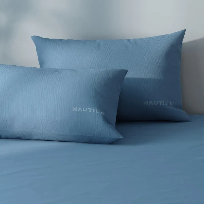 Close-up of two blue pillow covers on a matching bedsheet
