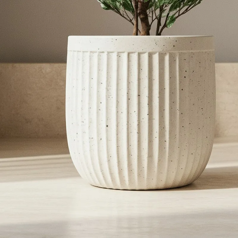 Close-up view of the off-white ribbed planter with a plant stem above it.