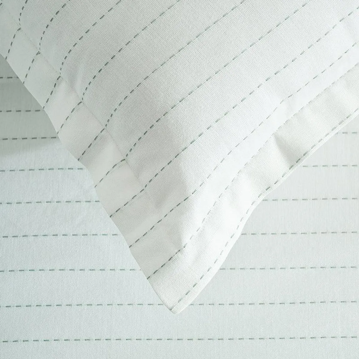 Close-up of white duvet cover showing subtle striped surface