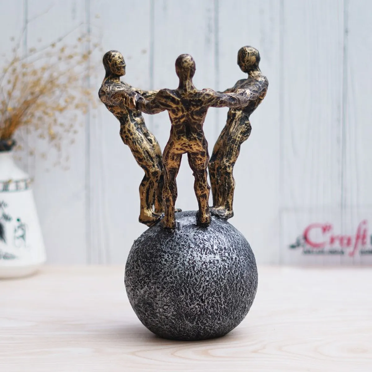 Angled view of gold and grey figurine showpiece on round base