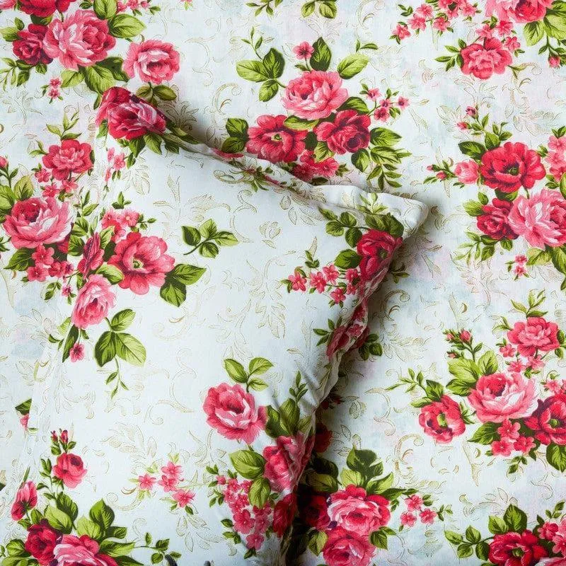 Close-up of white bedding with red and pink rose floral pattern