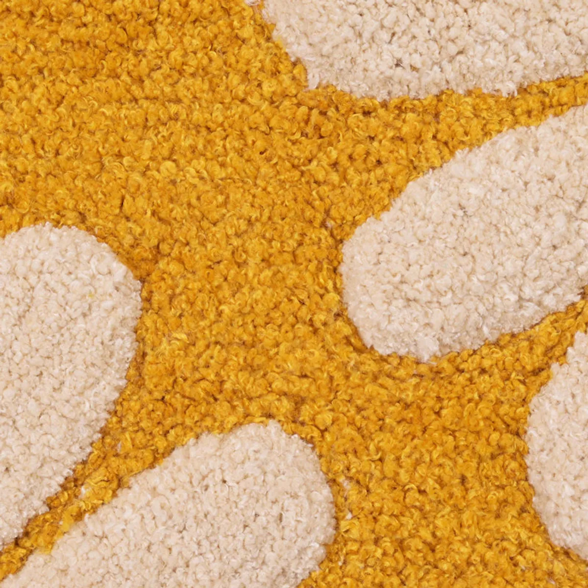 Detailed view of the cream daisy petals and yellow textured bathmat surface