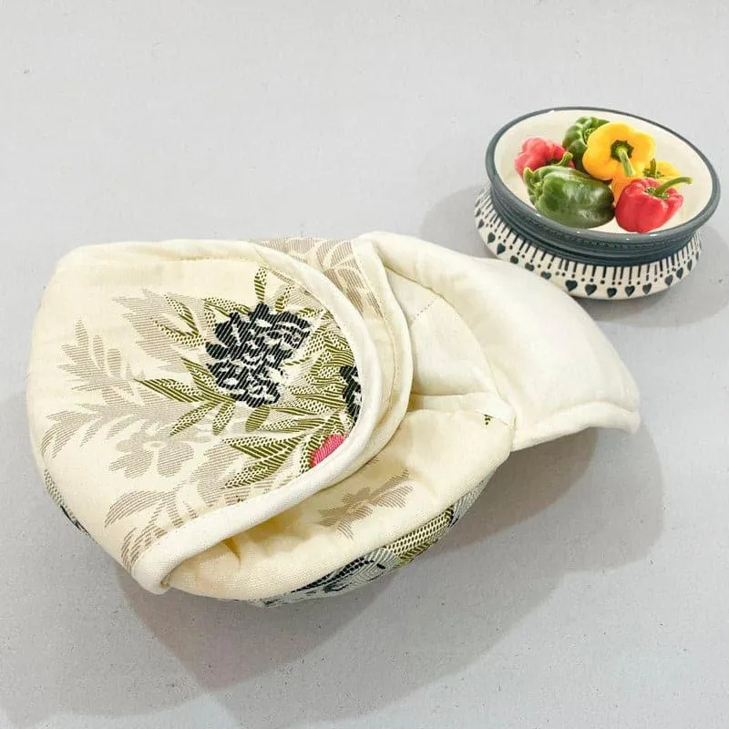White floral bread basket with cover beside a bowl of peppers