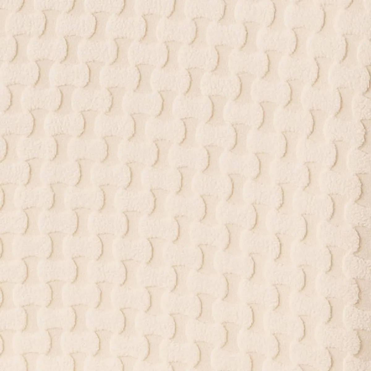 Close-up view of the chair covers' raised repeating surface texture in beige