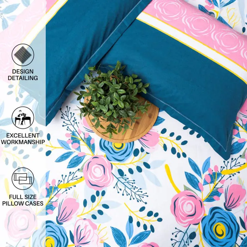 Close-up of two blue and pink pillow covers on floral bedsheet