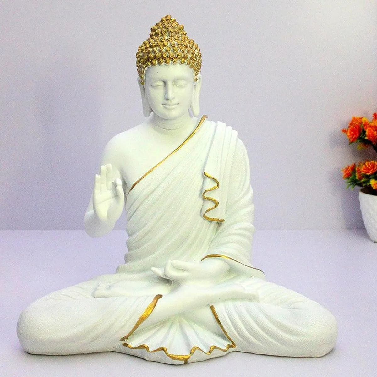 Front view of white seated Buddha showpiece with gold accents