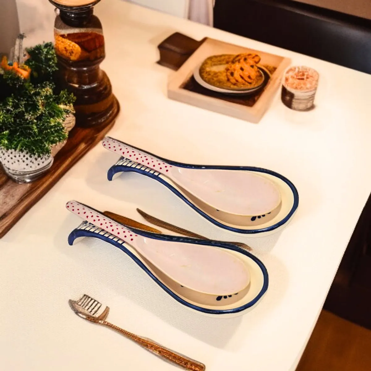 Two decorative ceramic spoon rests displayed on a light kitchen counter