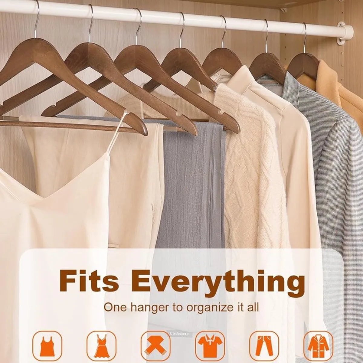 Set of brown wooden hangers holding assorted clothing in a wardrobe