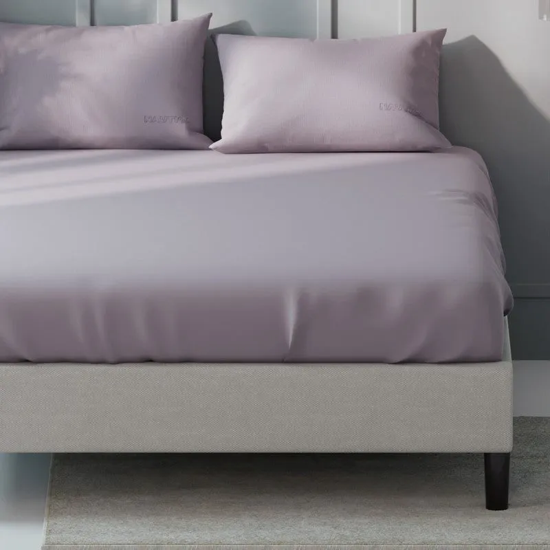 Close view of the smooth light pink bedsheet draped over a bed