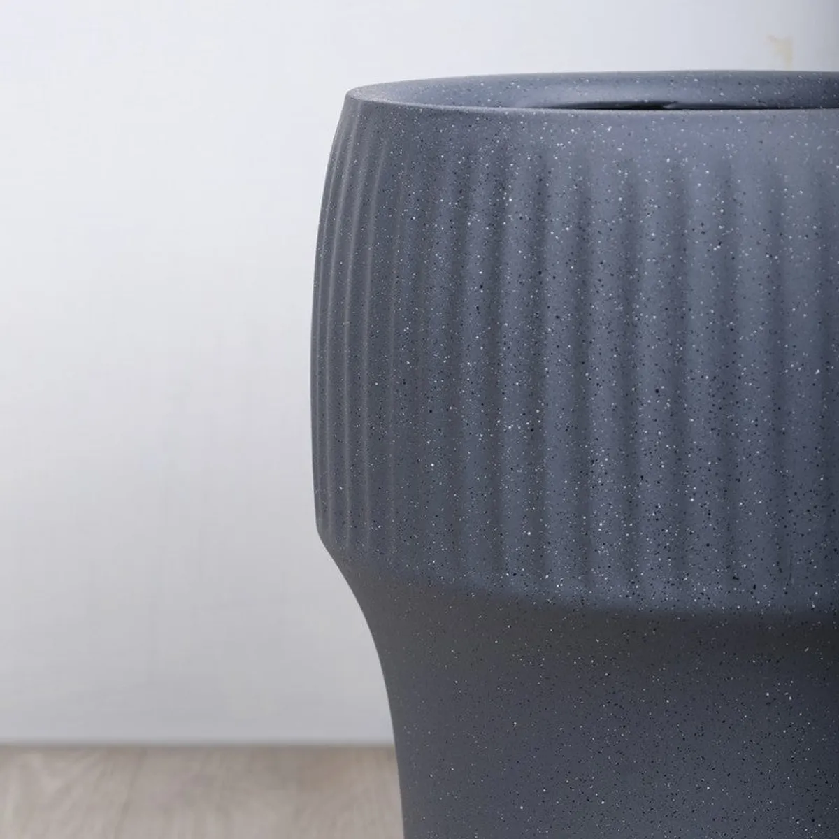 Close-up of the grey planter's vertical ribbing and textured matte surface