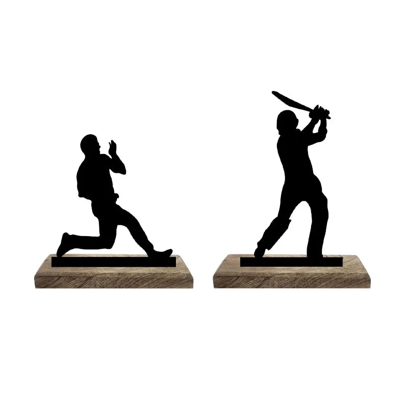 Two black cricket figurines on separate wooden bases shown side by side