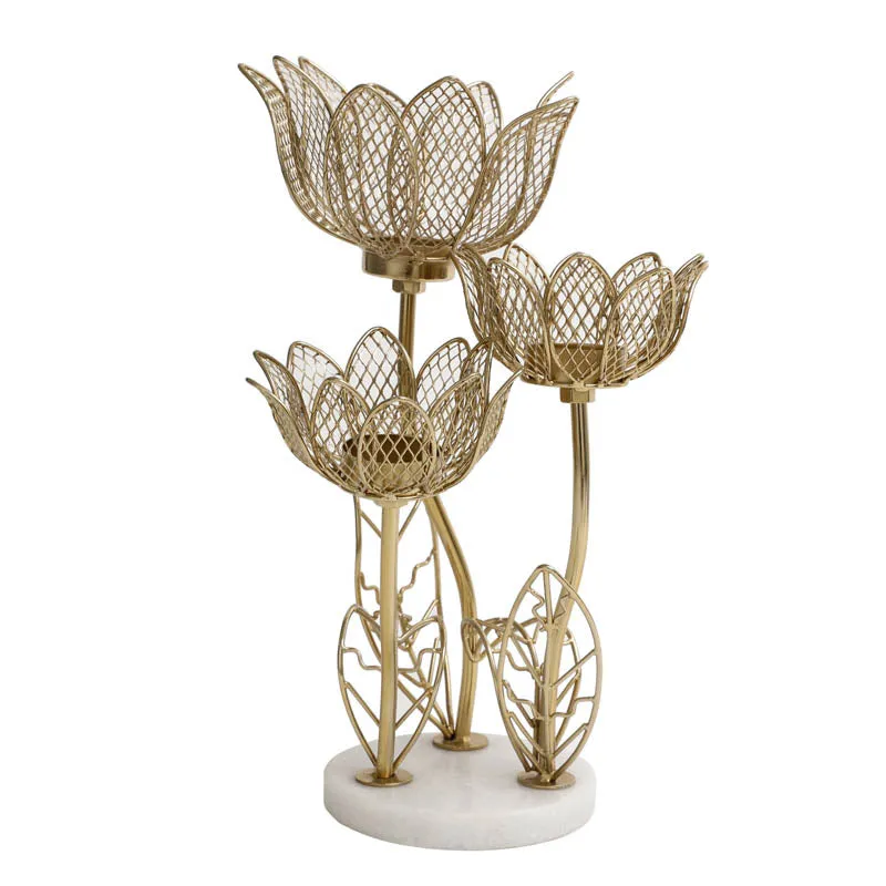 Angled view of gold-toned lotus candle holder with three flower cups