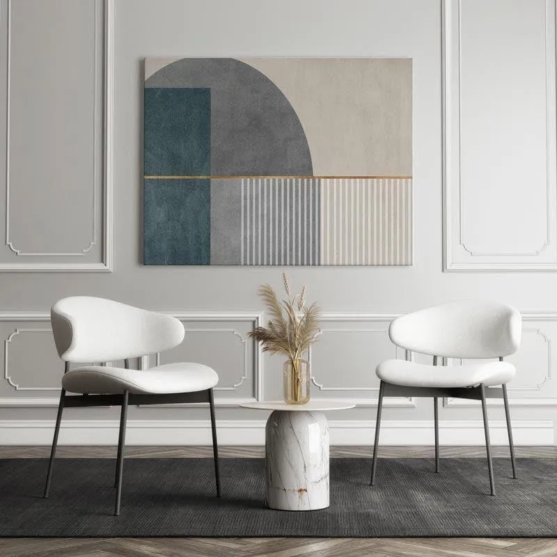 Geometric gallery wrap wall painting above two white chairs and a marble side table.