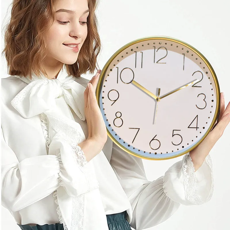 Person holding the round gold and white wall clock