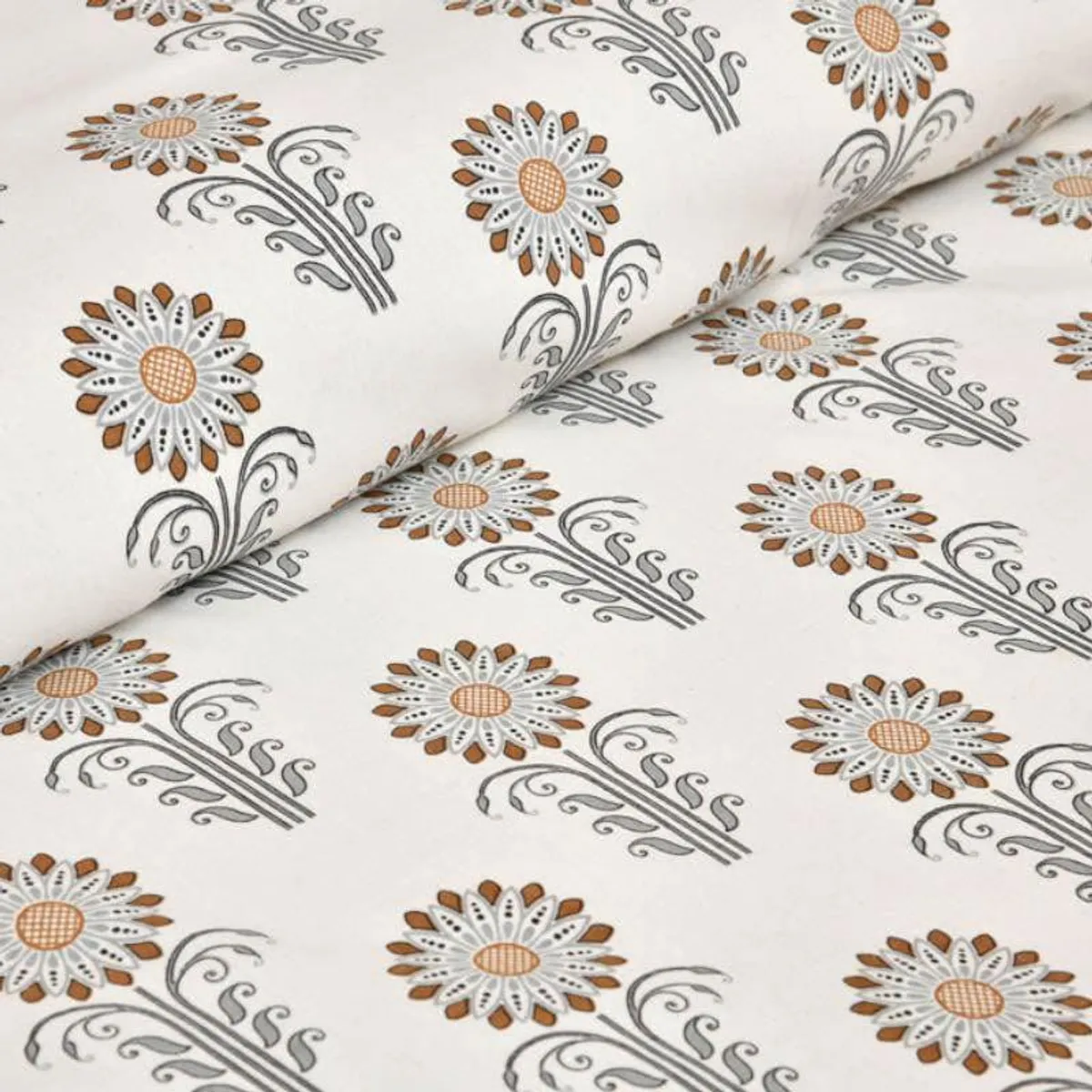 Close-up of bedsheet fabric with repeating floral print in grey and brown