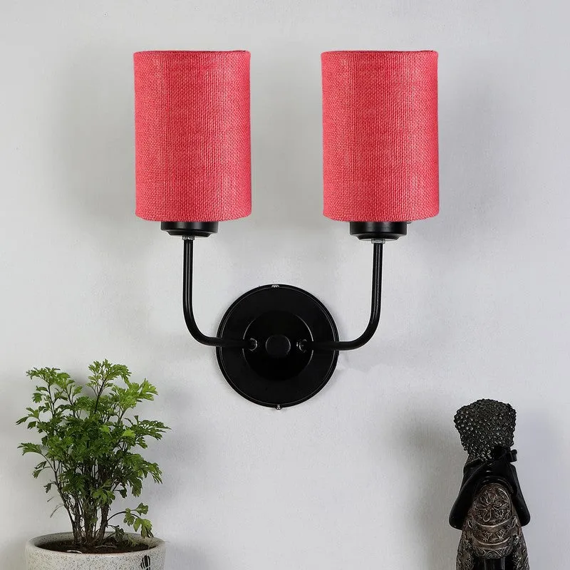 Front view of pink twin jute wall lamp with black round iron base