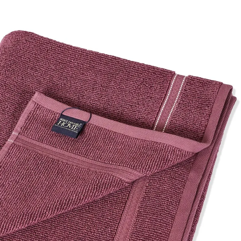 Close-up of the maroon towel's plush texture and attached label