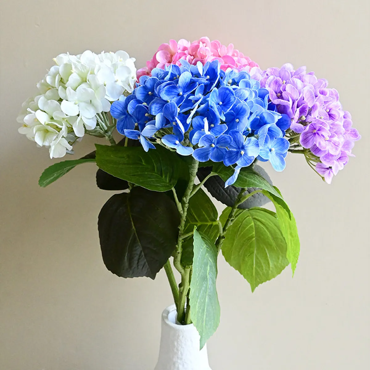 Blue artificial hydrangea stick displayed in a white vase